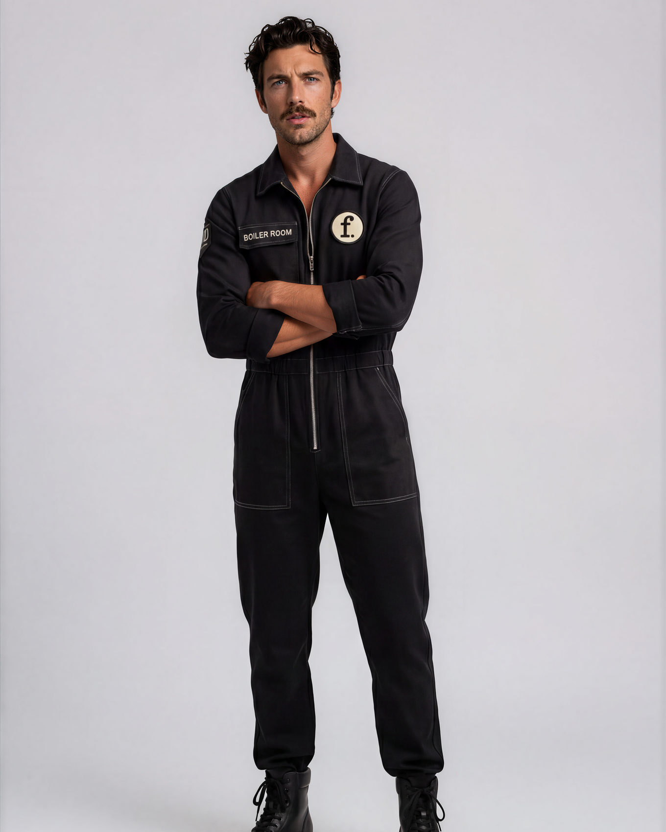 Man wearing a black jumpsuit with Foil Style patches on a white background