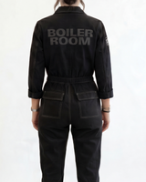 Person wearing a black boiler suit with 'BOILER ROOM' branding on a white background