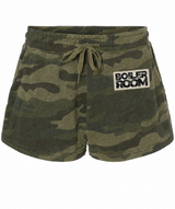 A pair of camouflage print lounge shorts with an elastic drawstring waist and a white 'BOILER ROOM' patch on the left hip, shown against a plain white background.