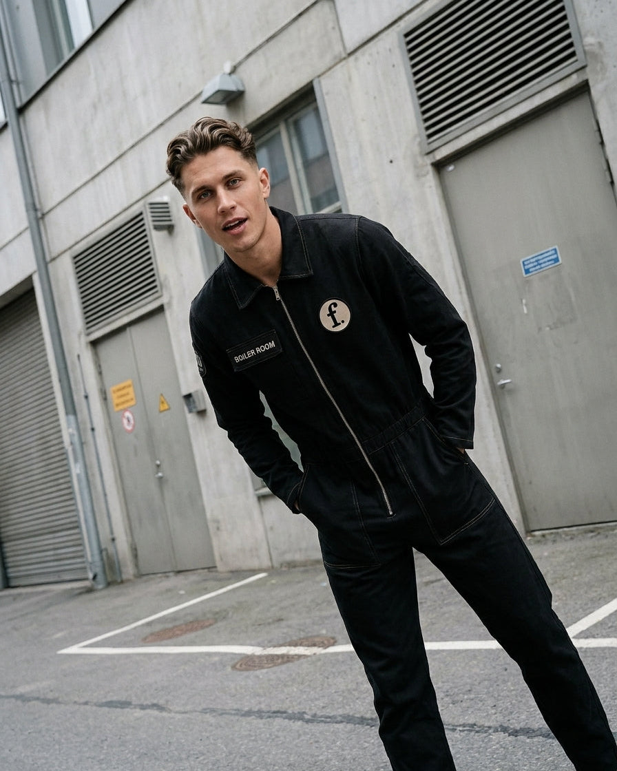 Man wearing a black coveralls with a Foil Style logo in an urban setting