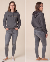 A woman modeling a dark gray hoodie with 'foistyle' printed on the chest, paired with gray skinny jeans and brown sneakers, shown in front and back views against a solid beige background.